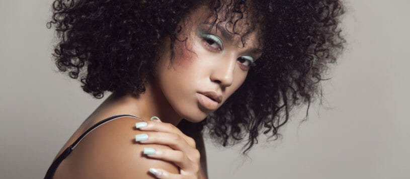 Portrait of a young mixed race woman woman with natural curly hair.